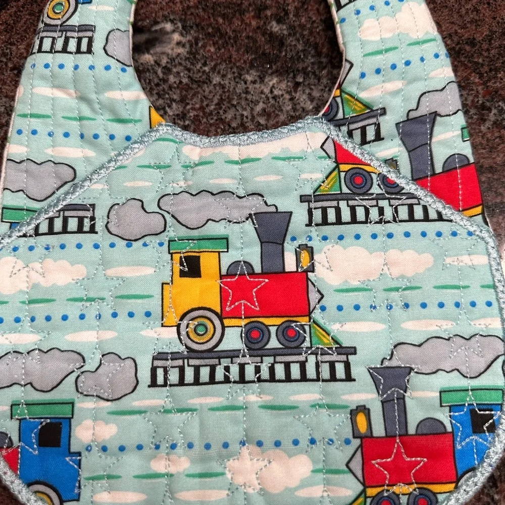 Handmade reversible quilted baby bib in train print